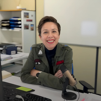 Headshot of Ana Guilló Recuerda, Biology Professor, smiling and sitting at a desk in front of a microphone.