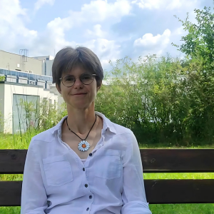 Headshot of Lenka Bittová, Molecular Biologist, sitting on a bench in the University park.