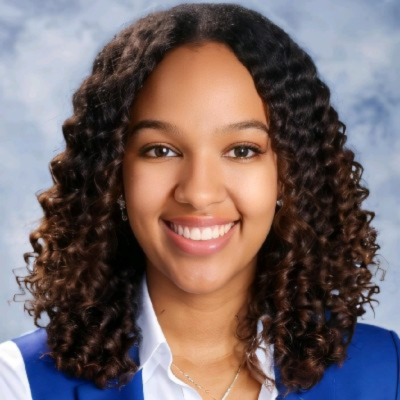 Headshot of Patrícia Pinheiro, Master's Degree in Aeronautical Maintenance Engineering, smiling in front of a blue background.